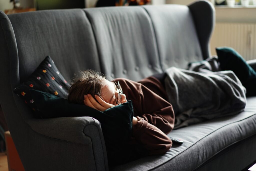 A woman sleeping comfortably on a sofa